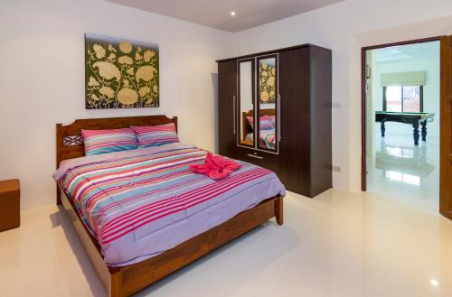 a bedroom with a bed with a red bow on it at RATANA VILLA - PATTAYA HOLIDAY HOUSE WALKING STREET 7 bedrooms in Pattaya South