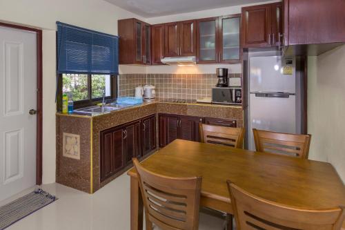 a kitchen with a wooden table and a refrigerator at RATANA VILLA - PATTAYA HOLIDAY HOUSE WALKING STREET 7 bedrooms in Pattaya South