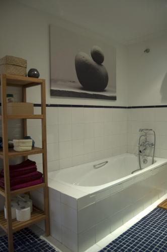 a bathroom with a bath tub and a vase on a shelf at Apartamentos Ondoloin in Vitoria-Gasteiz