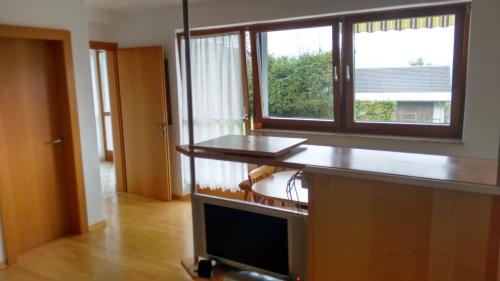 a kitchen with a desk with a window and a television at Gästehaus Monika in Reisach