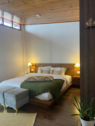 a bedroom with a large bed with white sheets and pillows at Triolet Bed and Breakfast in Shillong