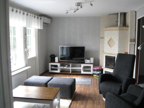 Katajaranta في Enonkoski: غرفة معيشة مع تلفزيون بشاشة مسطحة وكرسيين