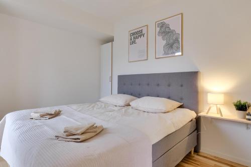 a bedroom with a white bed with two towels on it at Fantastisk bolig midt i Odense C in Odense