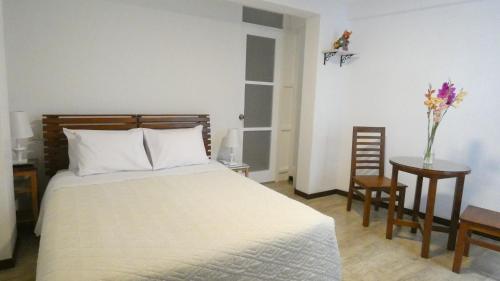 a bedroom with a bed and a table with a vase of flowers at MAKEYA Home-Hotel in Churín