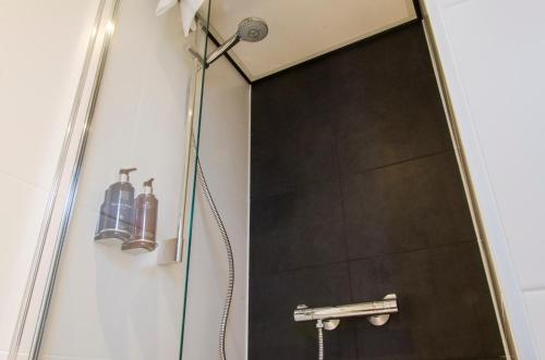 a shower with a shower head in a bathroom at City2Beach Hotel in Vlissingen