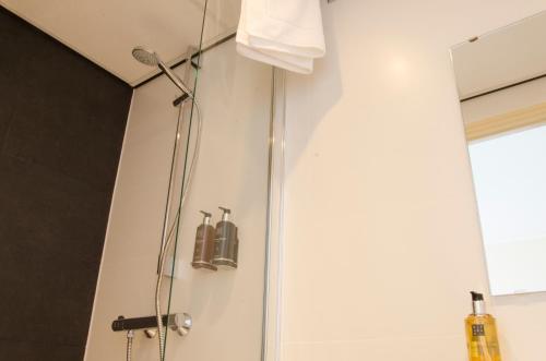 a shower in a bathroom with a glass door at City2Beach Hotel in Vlissingen
