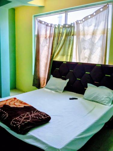 a bed in a room with a large window at Virasat Guest House in Lucknow