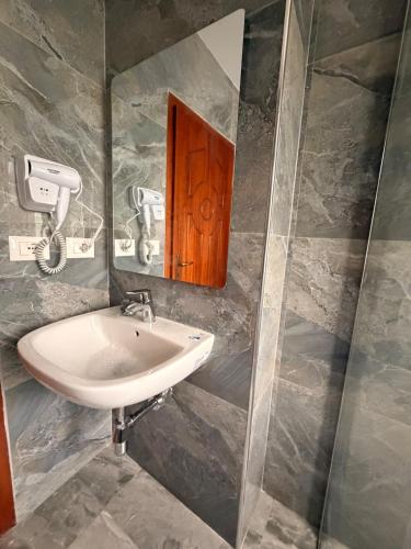 a bathroom with a sink and a mirror at The Green Loft in Fushë-Arrëz