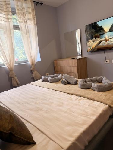 a bedroom with a large bed with three pillows on it at The Green Loft in Fushë-Arrëz