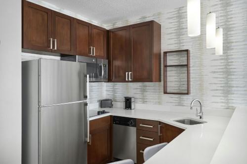 a kitchen with wooden cabinets and a white refrigerator at Residence Inn by Marriott Charlotte Airport in Charlotte