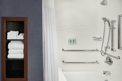 a bathroom with a shower and a toilet and towels at Residence Inn by Marriott Charlotte Airport in Charlotte