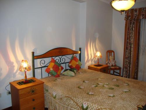 ein Schlafzimmer mit einem Bett und zwei Lampen an einer Kommode in der Unterkunft Apartamento Artur in Lousã