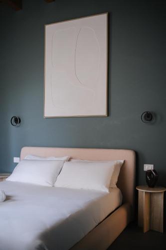 a bedroom with a white bed with a picture on the wall at The Tower Premium Apartment - Beams & Views - 3 Min Walk to Bernina Express & Station in Tirano