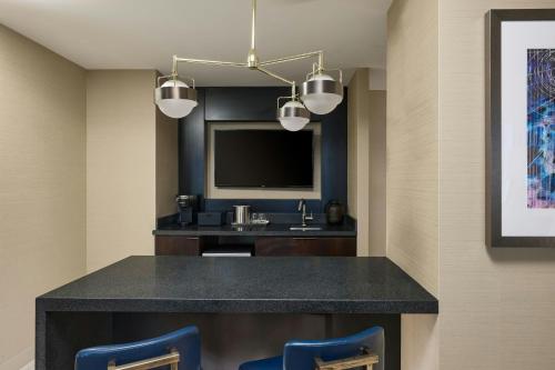 a hotel room with a bar with a sink and a tv at Marriott Marquis Houston in Houston