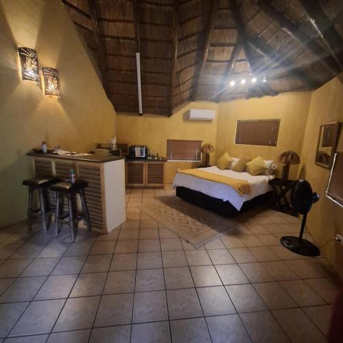 a bedroom with a bed and a kitchen in a room at Jabula Kruger Safari Lodge in Marloth Park