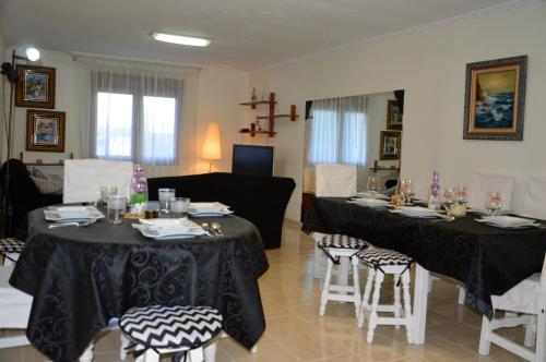 een woonkamer met 2 tafels en stoelen en een bank bij Casa Vacacional Mazo de Arriba in Santander