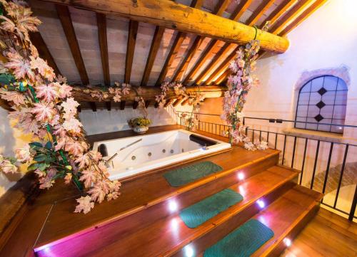 a jacuzzi tub in a room with wooden ceilings at Monastery Birbino in Le Ville