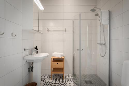 a white bathroom with a sink and a shower at L Boutique Hotel in Lysekil