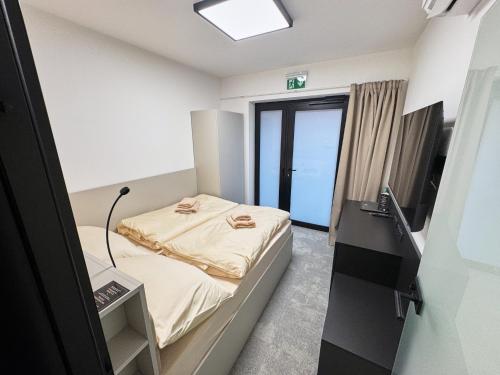 a small room with a bed and a television at Mondeso Hotel in Aš