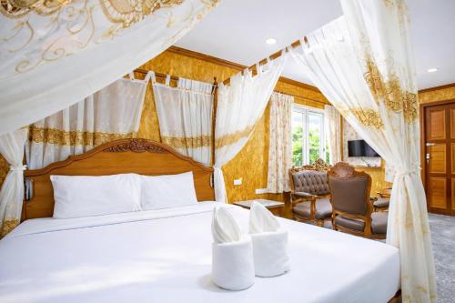 a bedroom with a bed with a canopy at Chatsuree Boutique Resort in Ubon Ratchathani