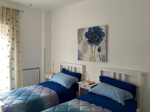 a bedroom with two beds and a painting on the wall at Hibiscus in Taranto