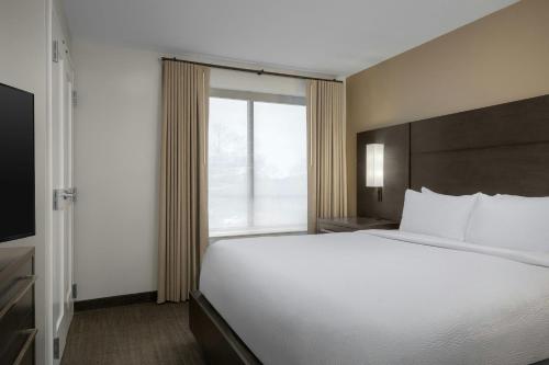 a large bed in a hotel room with a window at Residence Inn by Marriott Charlotte Northlake in Charlotte