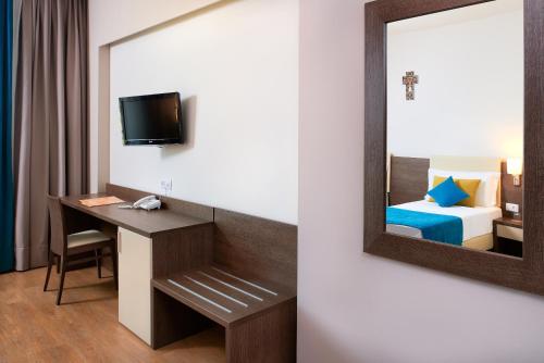 a room with a mirror and a desk and a bed at Medjugorje Hotel & Spa in Međugorje