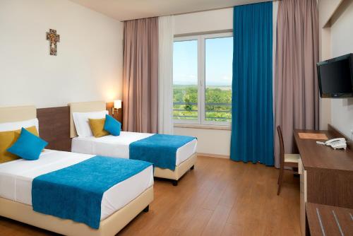 a hotel room with two beds and a window at Medjugorje Hotel & Spa in Međugorje