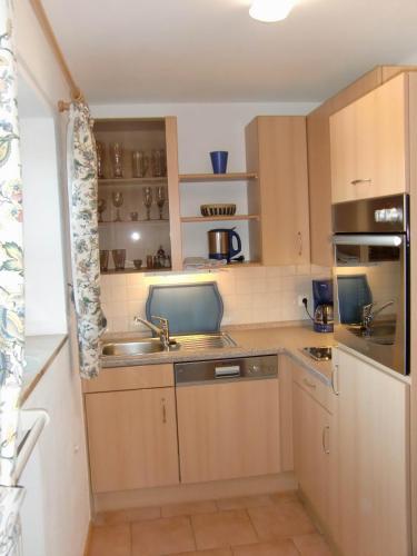 a kitchen with wooden cabinets and a sink at Fewo Bergruah in Bad Bayersoien