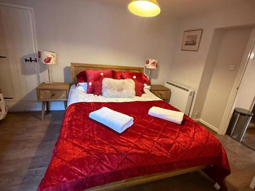 a bedroom with a large red bed with two pillows at The Bittern in Holt