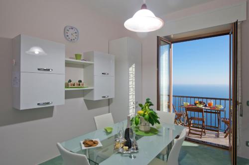 a kitchen with a table and chairs and a balcony at Calipso Residence in Furore