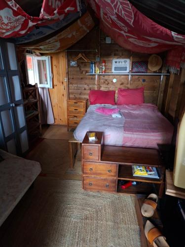a bedroom in a log cabin with a bed and a desk at Chalet en bois accés piscine in La Possession