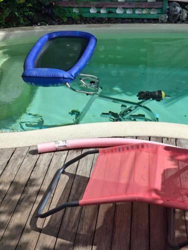a bike in a swimming pool with a raft at Chalet en bois accés piscine in La Possession