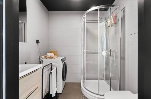 a bathroom with a shower and a washing machine at Modern apartment with two bedrooms in Hektner