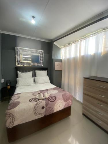 a bedroom with a large bed and a dresser at Day&Night Stay in Johannesburg