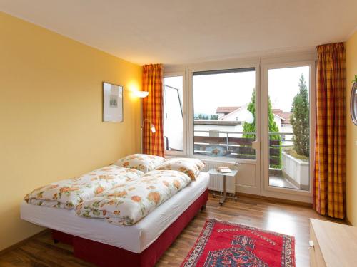 - une chambre avec un lit et une grande fenêtre dans l'établissement Rosenalm Appartment 208, à Scheidegg