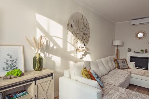 a living room with a white couch and a table at Loft Amalia w wieży strażackiej, butikowy, blisko jeziora in Szczecinek