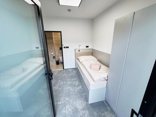 a small bathroom with a bed and a tub at Mondeso Hotel in Aš