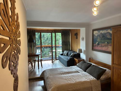 a bedroom with a bed and a living room at Willa Karolina Centrum Zakopane in Zakopane