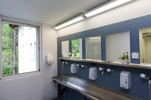 a bathroom with a blue wall with mirrors at Casa di vacanza Giovanibosco in Bosco Gurin