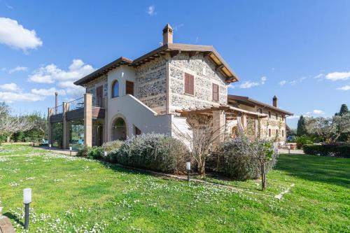 a stone house with a green yard in front of it at Casale Elisa Country Hotel in Ladispoli