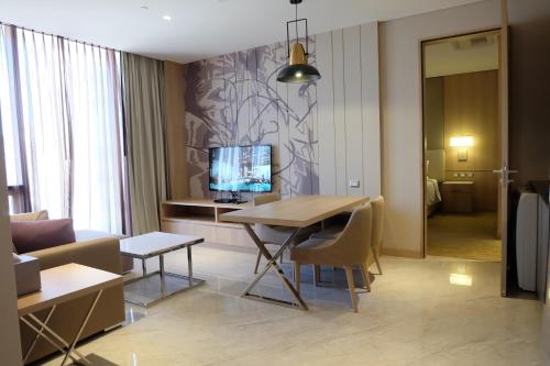 a living room filled with furniture and a tv at SKYVIEW Hotel Bangkok - SHA Extra Plus in Bangkok