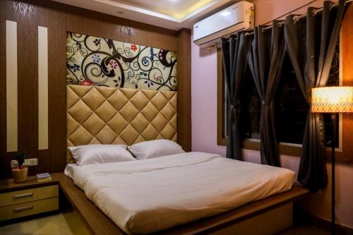 a bedroom with a bed with a headboard and a window at Fussed Over Retreat in Siliguri