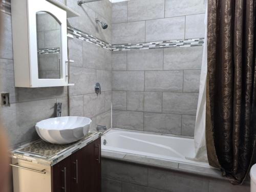 a bathroom with a white tub and a sink at Marbyn & Ana House in Tegucigalpa