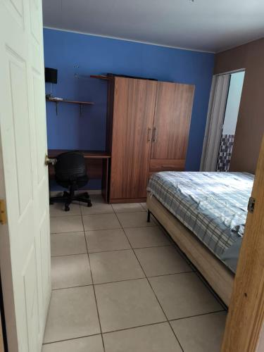 a bedroom with a bed and a desk and a chair at Marbyn & Ana House in Tegucigalpa