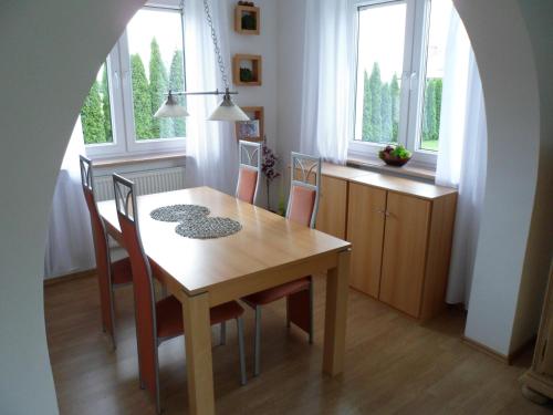 Holiday Home Mierki في أولشتينيك: طاولة طعام وكراسي في غرفة بها نوافذ