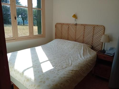 a bed sitting in a bedroom with a window at Petite Perle Parinet in La Croisille-sur-Briance
