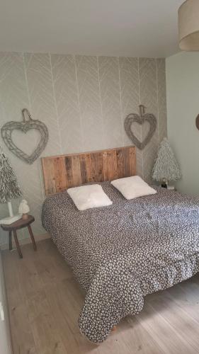 a bedroom with a bed with two hearts on the wall at gite l oree de la foret in Incheville