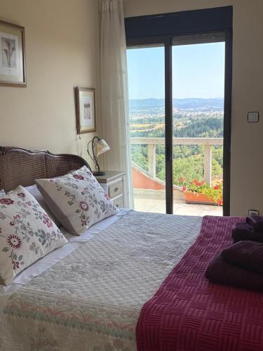 a bedroom with a bed and a large window at leiradaporta in Monforte de Lemos