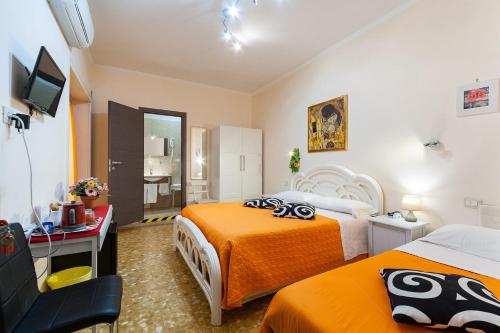 ローマにあるVatican Golden Roomsのベッド2台とテレビが備わるホテルルームです。